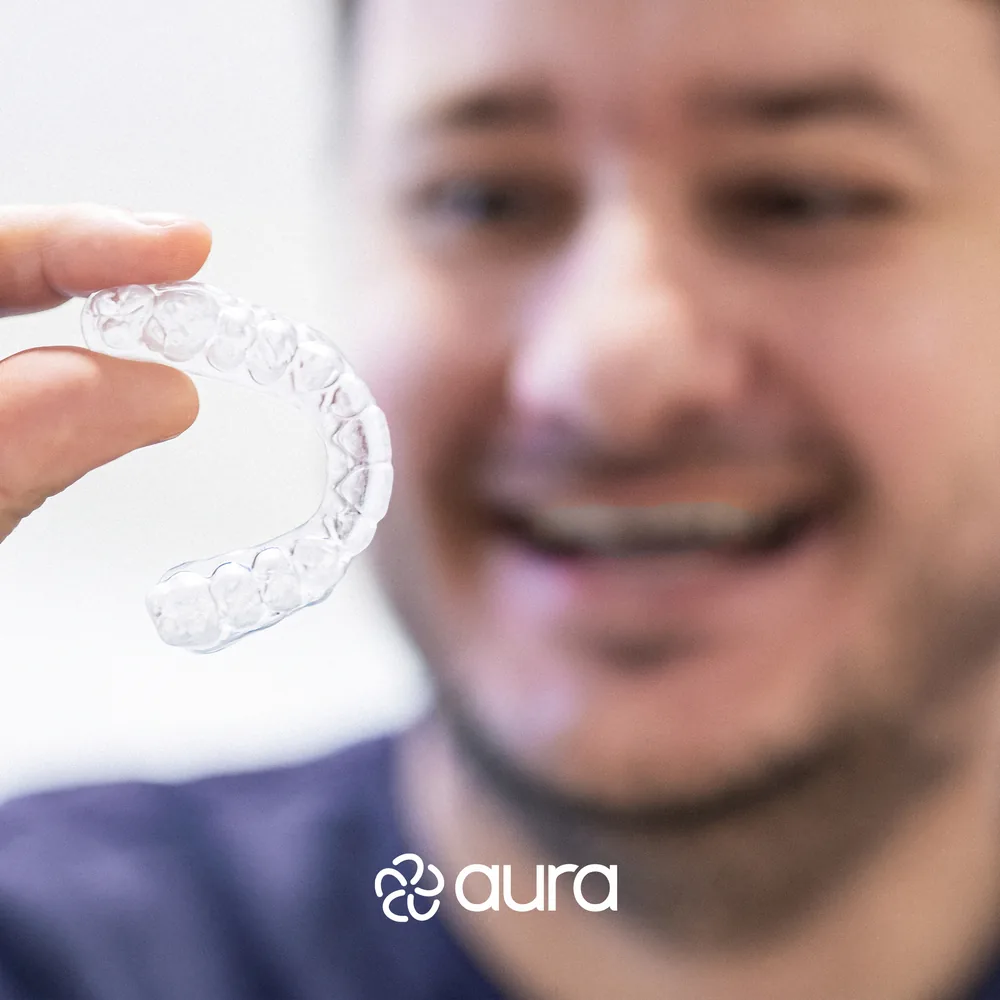 Persona mostrando un alineador transparente